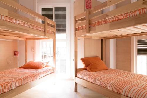 two bunk beds in a room with a window at Chinitas Urban Hostel in Málaga