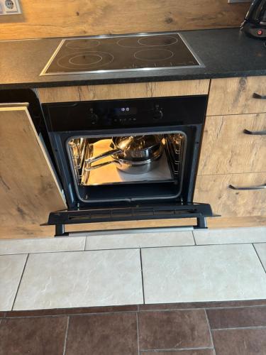 an oven with a pot and pans inside of it at Alpinchalet Eder - Steiner in Saalbach-Hinterglemm