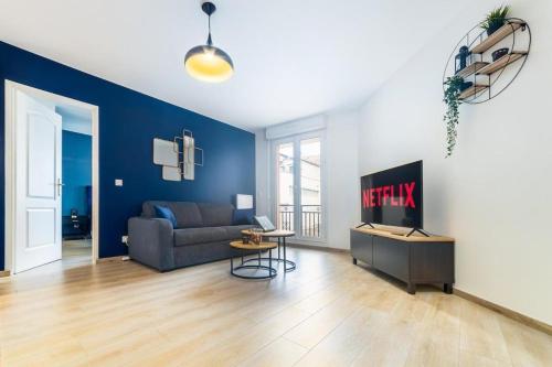 un salon avec un canapé et une télévision dans l'établissement Appartement L'Îlot Bleu Paradis, à Melun