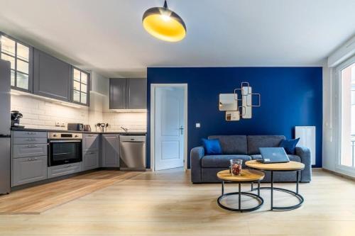 a living room with a couch and a table with a laptop at Appartement L'Îlot Bleu Paradis in Melun