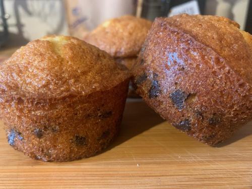 three muffins sitting on a wooden cutting board at Chambres d'Hôtes La Petite Odile in Boersch