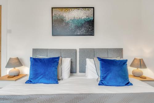 a bedroom with a bed with blue pillows at Park View House Close to Central Park and Plymouth Argyle FC - Dogs welcome - Hosted by Absolute Accommodation Plymouth in Plymouth