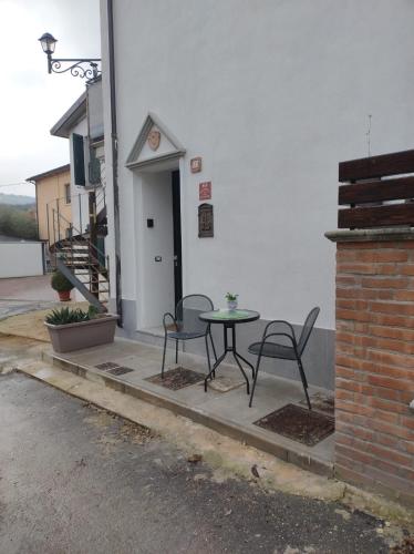 a patio with two chairs and a table in front of a building at RELUX ROMAGNA in Fiumana