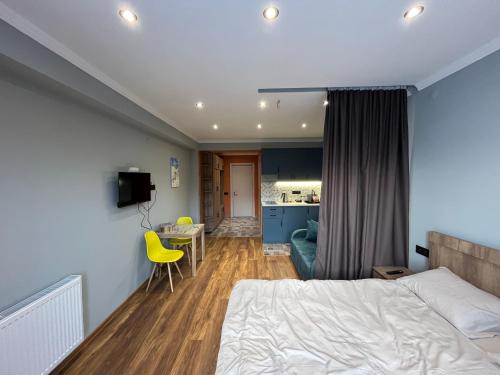 Un dormitorio con una cama y una mesa y una cocina. en Cozy apartment in NEW GUDAURI Block F2, en Gudauri