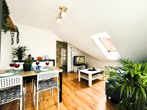 kuchnia i salon ze stołem i krzesłami w obiekcie Apartament Słoneczny 1 w mieście Opole
