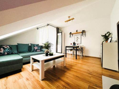salon z zieloną kanapą i stołem w obiekcie Apartament Słoneczny 1 w mieście Opole