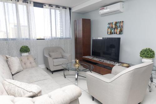 a living room with white furniture and a fireplace at Stylish and Modern Oasis in Windhoek