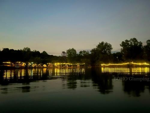 a view of a harbor with boats in the water at night at BOHO Glamping - CẮM TRẠI HỒ TRỊ AN in Ấp Phú Cát
