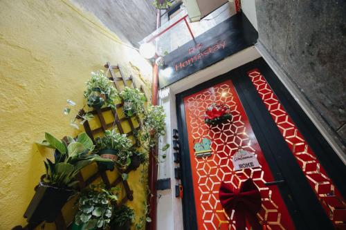 a red door with plants on the side of a building at Rik Homestay in Hanoi