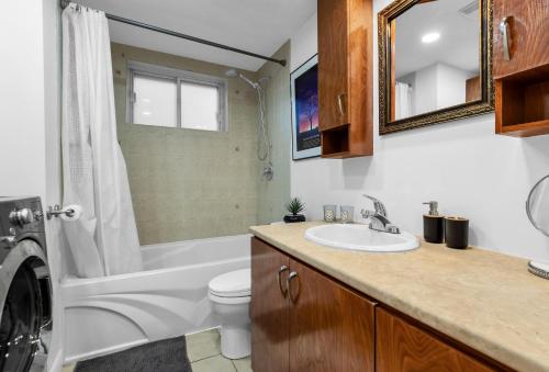 a bathroom with a sink and a washing machine at COSY 3 BEDROOMS Montreal in Montréal