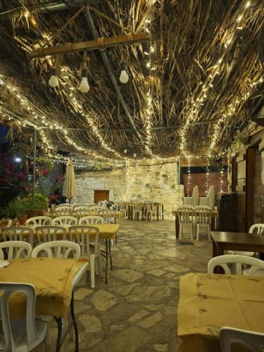 ein Esszimmer mit Tischen, Stühlen und Lichtern in der Unterkunft Eleni's Cottage in Apsiou