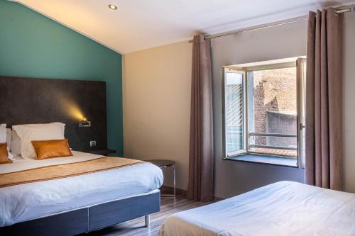 a hotel room with two beds and a window at LOGIS Hôtel de Bourgogne - Mâcon in Mâcon