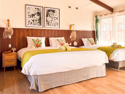 a bedroom with two beds with white and green sheets at Tahai Loft Apart Hotel in Hanga Roa