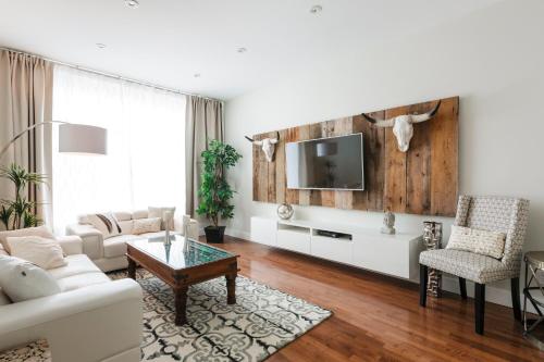 a living room with a couch and a tv at MTLVacationRentals - The FabFour in Montreal