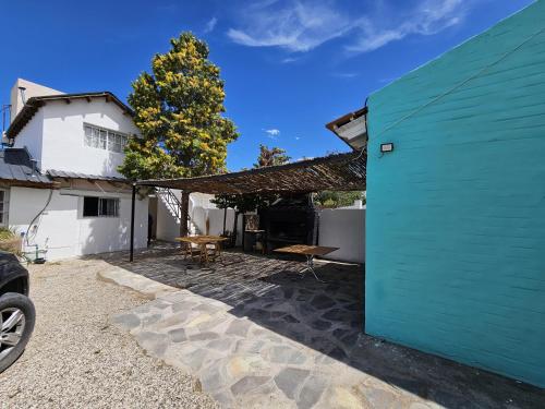 ein blaues Gebäude mit einem Picknicktisch im Hof in der Unterkunft Postal del Golfo in Las Grutas