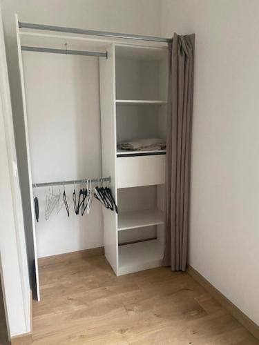 Cette chambre dispose d'un placard avec une porte ouverte. dans l'établissement Séjour proche Paris & Disney, à Lésigny
