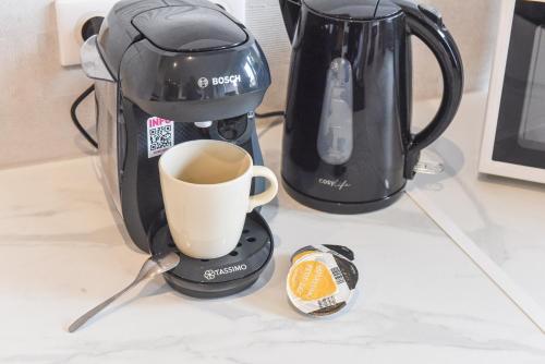 une cafetière et une tasse sur un comptoir dans l'établissement Le Repaire Du Grizzly, à Mulhouse