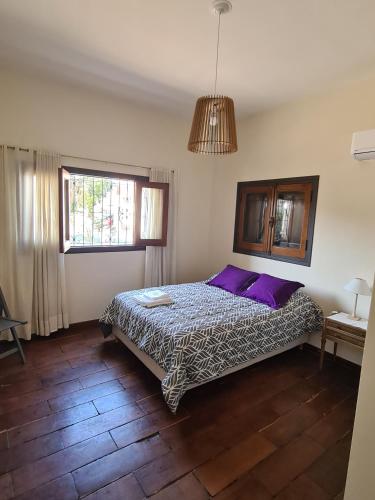 a bedroom with a bed with purple pillows at LA CASA de la ALEM 1 in La Rioja