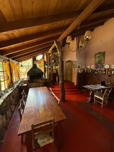 Großes Zimmer mit einem Holztisch und einem Kamin. in der Unterkunft La Posta del Mistol in Las Tapias