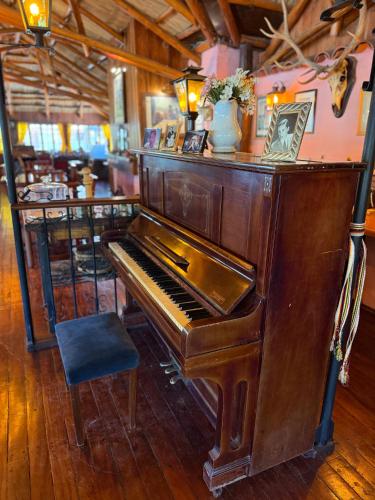 ein altes Klavier in einem Zimmer mit Stuhl in der Unterkunft La Posta del Mistol in Las Tapias