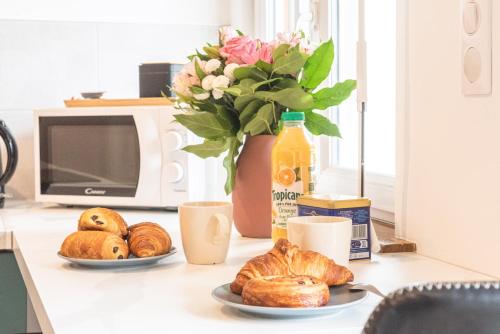 une table avec deux assiettes de pâtisseries et un vase avec des fleurs dans l'établissement Le Repaire Du Grizzly, à Mulhouse