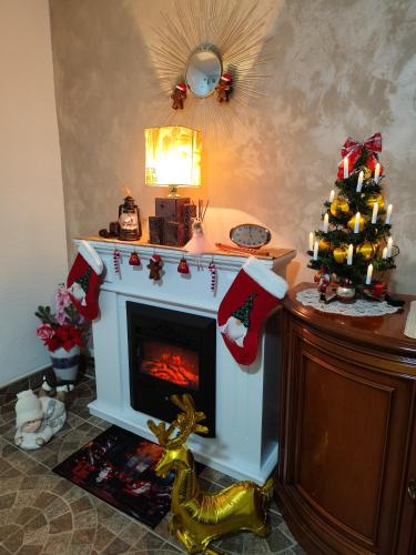a living room with a fireplace with a christmas tree at Zeleni raj in Hreljin Ogulinski