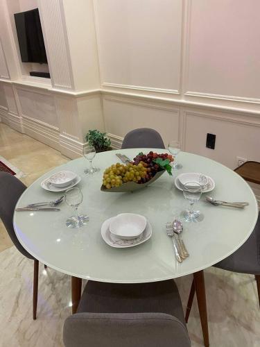 a white table with a bowl of grapes and wine glasses at برج داماك الكورنيش جدة - Damac Tower Corniche Jeddah in Jeddah