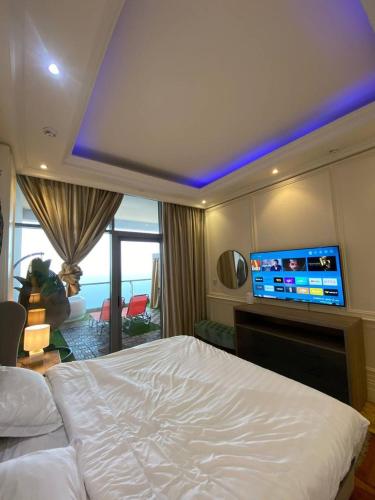 a bedroom with a bed and a tv on the wall at برج داماك الكورنيش جدة - Damac Tower Corniche Jeddah in Jeddah