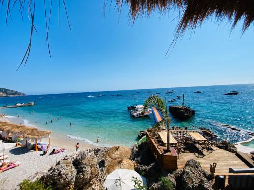 a beach with a bunch of people in the water at Kotarja Apartments in Dhërmi