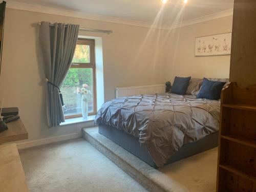 a bedroom with a bed and a window at Shore Cottage A traditional cosy cottage in Wilpshire