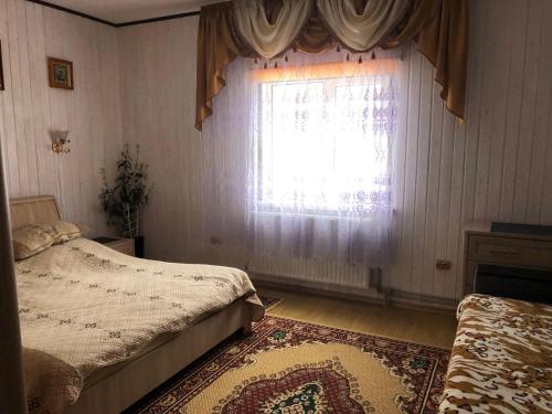 a bedroom with two beds and a window at Біля комори in Pilipets