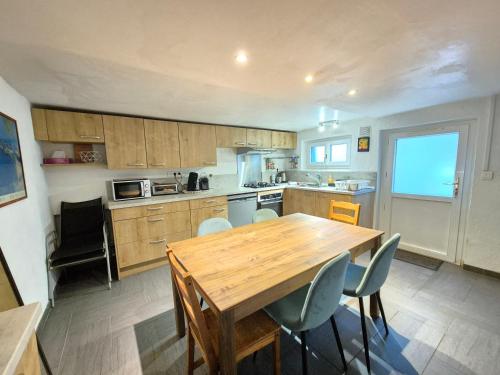 une grande cuisine avec une table et des chaises en bois dans l'établissement Le Mallet #Jardin#Central, à Clermont-Ferrand