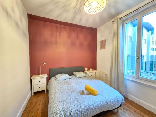 une chambre avec un lit et un mur rouge dans l'établissement Le Mallet #Jardin#Central, à Clermont-Ferrand