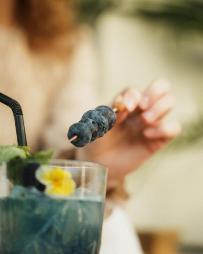 a person holding a piece of food in a drink at Hotel Estepona Plaza in Estepona