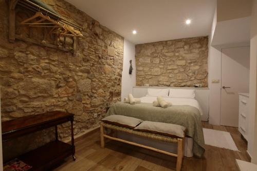 a bedroom with a bed in a stone wall at Old Side Girona One in Girona