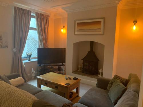 a living room with a couch and a fireplace at Shore Cottage A traditional cosy cottage in Wilpshire