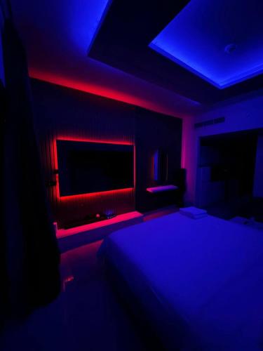 a bedroom with a bed and a blue and red lighting at برج داماك الكورنيش جدة - Damac Tower Corniche Jeddah in Jeddah