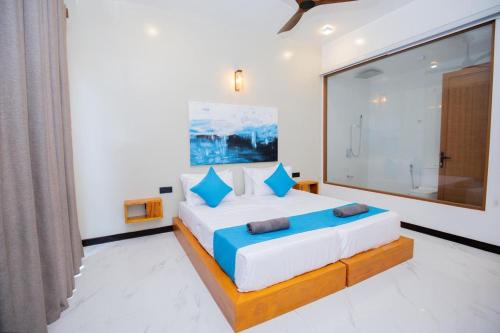 a bedroom with a large bed with blue pillows at Liya Beach Kathaluwa - Ahangama in Ahangama