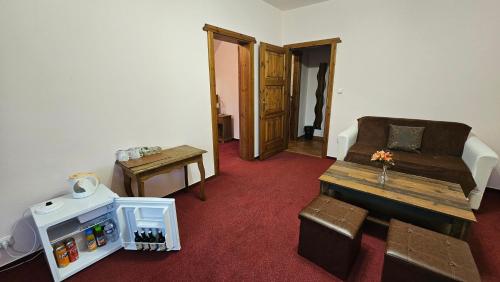 a room with a couch and a table and a chair at Hotel Opat in Kutná Hora