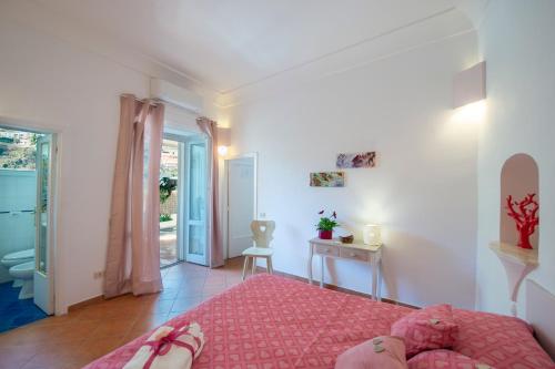 a bedroom with a pink bed with a pink rug at Positano Casa Delizia in Positano