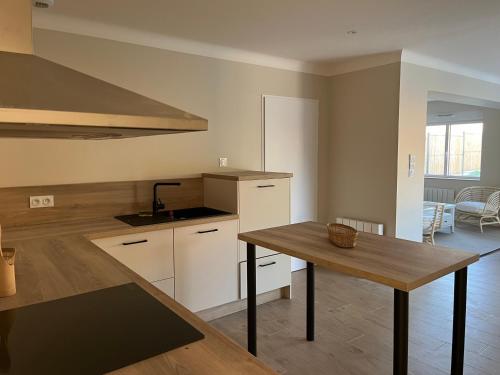 une cuisine avec une table et un comptoir dans l'établissement Villa chaleureuse 8 personnes - Nouveau, à Port-Saint-Père