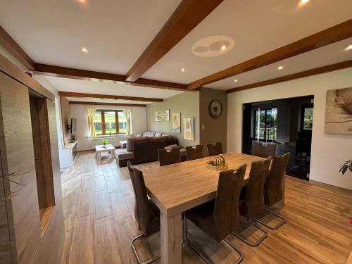 a dining room with a wooden table and chairs at Villa De Miguel in Paliseul