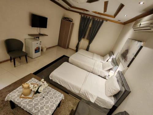 a living room with a white couch and a table at الينبوع الأخضر in Al Madinah