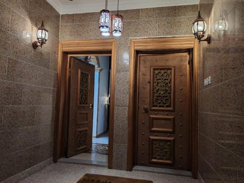 a hallway with two wooden doors and a mirror at الينبوع الأخضر in Al Madinah