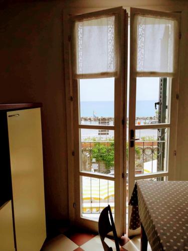 two windows in a kitchen with a view of a balcony at Giada in Moneglia