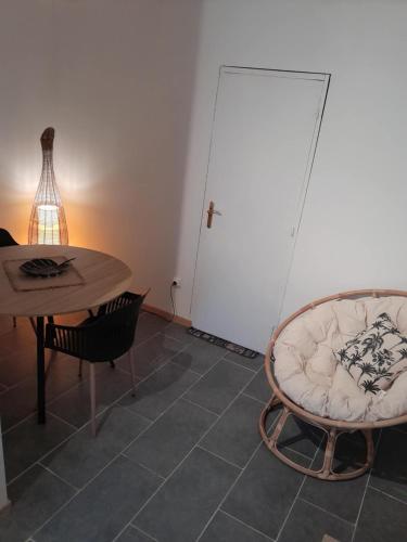 une chambre avec une table, une chaise et une porte dans l'établissement La paloma, à Dun-le-Palestel
