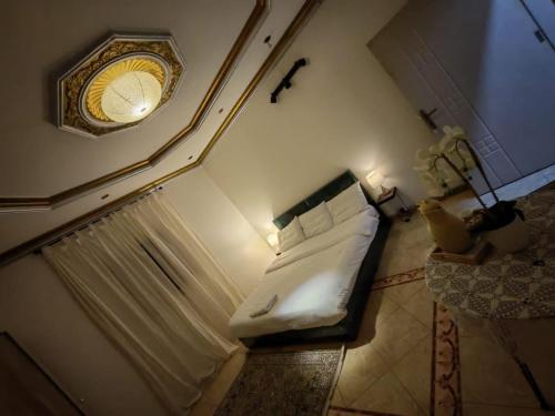 a small bedroom with a bed and a clock on the wall at الينبوع الأخضر in Al Madinah