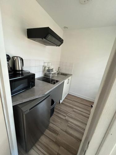 une petite cuisine avec un évier et un micro-ondes dans l'établissement Parfait F1, Entrée du Havre #7, au Havre