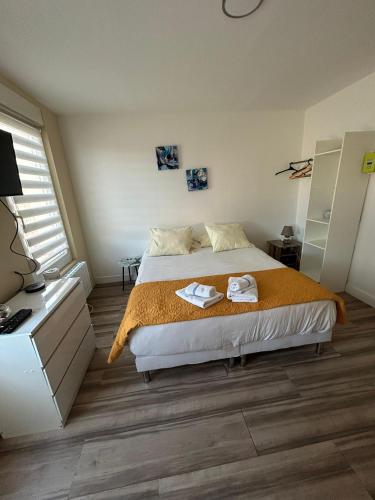 une chambre avec un lit avec deux serviettes dessus dans l'établissement Parfait F1, Entrée du Havre #7, au Havre