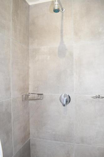 a shower with a shower head in a bathroom at House on Pringle in Cape Town